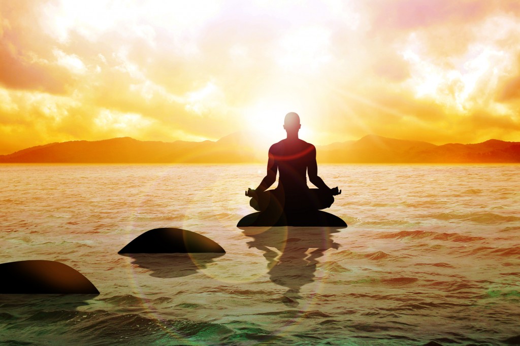 A man figure meditating on calm water during sunrise